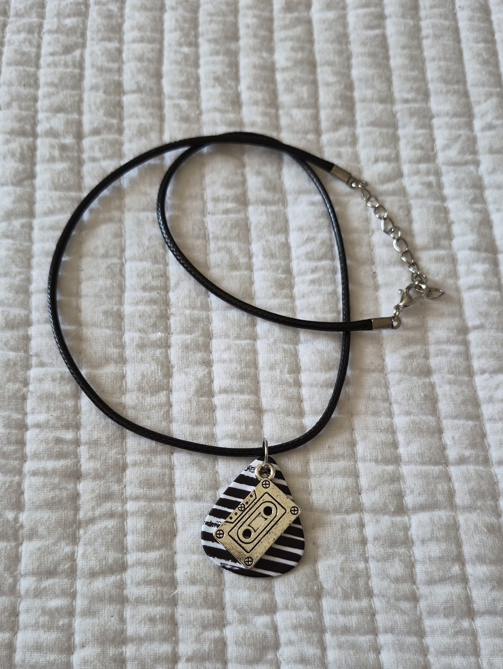 Black Cord Necklace with A Black And White Guitar Pick and Silver Cassette Charm